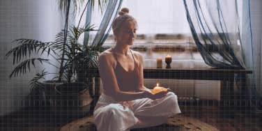 Woman lighting a candle, meditating 