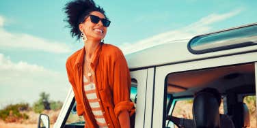 woman enjoying window view of desert and traveling in a van