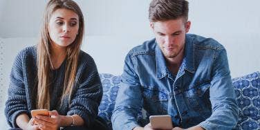 woman and man sitting together on couch looking blankly