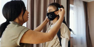 Mom putting mask on daughter