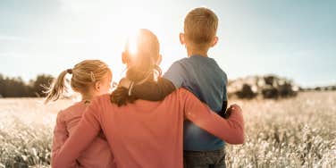 mom and two kids in field