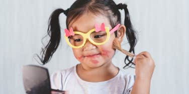 little girl playing in makeup