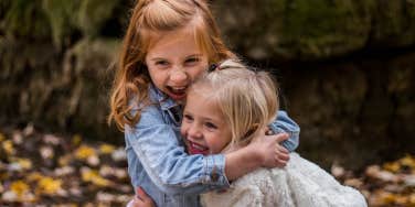 two little girls laughing and hugging each other