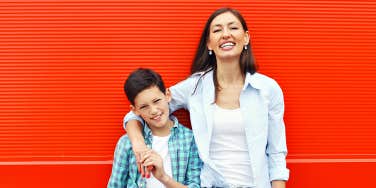 Mother and child against a red textured background, smiling