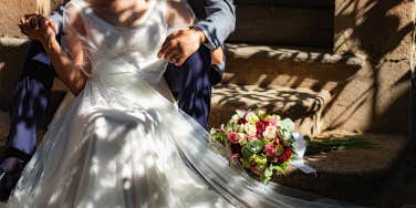 bride and groom sitting on stairs outside