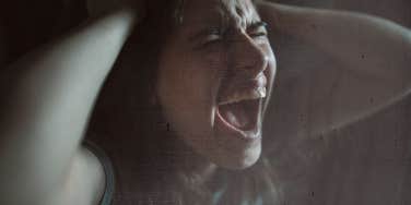 Woman screaming holding her head, anger and sadness