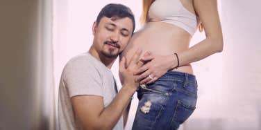 man listening his pregnant wife's balley 