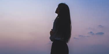 silhouette of woman with purple sky