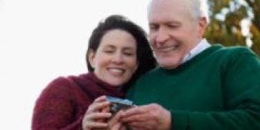 older happy married couple looking at photos