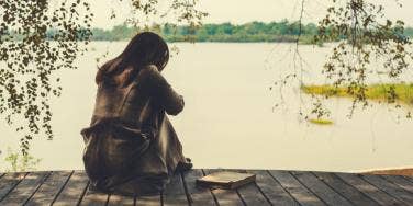 woman sitting by water