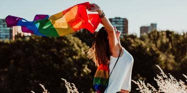 woman holding up a gay pride flag
