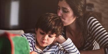 woman kissing child on head