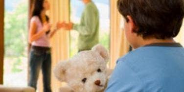 parents fighting in front of son holding teddy bear