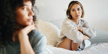 Couple looking unhappy in a bedroom, dysfunctional refusal to look at one another