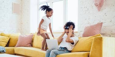 mom with kid jumping on couch