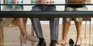 man playing footsie two women polygamy