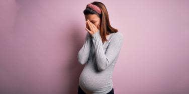 pregnant woman with face in hands