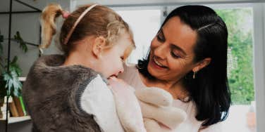 mom holding young daughter