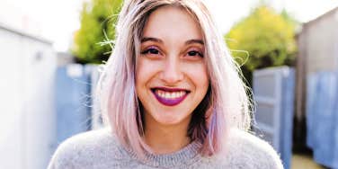 woman with trendy white hair smiles at the camera 