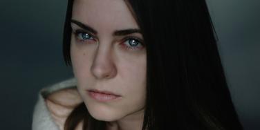 woman with black long hair staring into camera