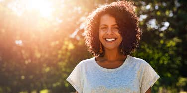 Confident, relaxed woman smiles outside