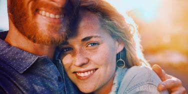 smiling woman hugging bearded man
