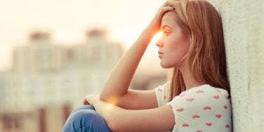 woman touching hand to forehead