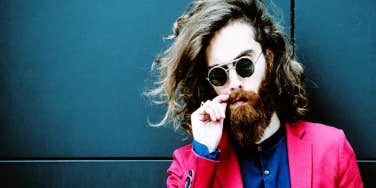 man with sunglasses touching mustache