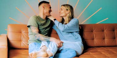 Couple, sitting closely smiling, reconnecting on couch