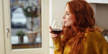 red-haired woman drinking red wine