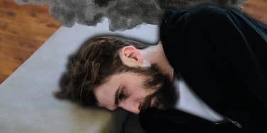 Depressed man laying on couch, zoning out 