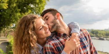 man kissing woman on cheek