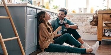 couple talking on the floor of a kitchen