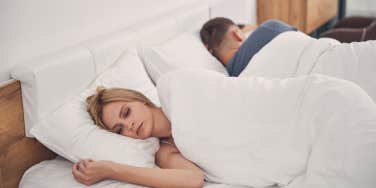 unhappy couple facing away in bed