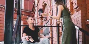 woman yelling at boyfriend sitting on stairs outside
