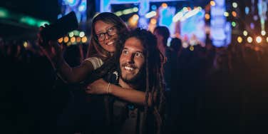 man and woman taking photo at a concert