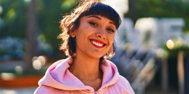 smiling girl in pink hoodie