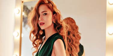 glamorous woman with red hair in a green dress