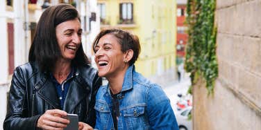 two middle aged women laughing 