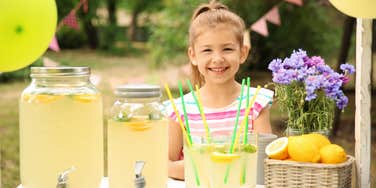 little girl behind lemonade stand