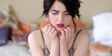 shy woman sitting on bed