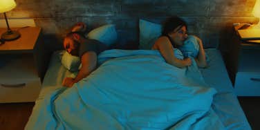 couple sharing bed unable to sleep