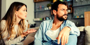 woman apologizing to her boyfriend while sitting on the couch