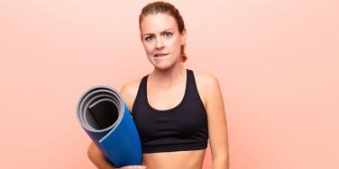 uncertain woman with yoga mat