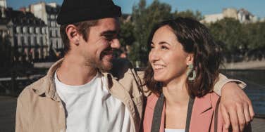 man with arm around woman's shoulders