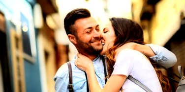 smiling man embracing woman playfully biting his cheek