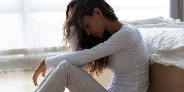 woman sitting sadly edge of bed