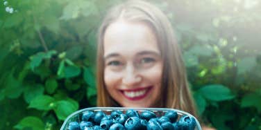woman holding blueberries