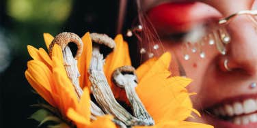smiling girl next to sunflower and mushrooms