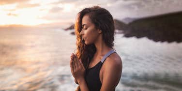 woman praying by the beach